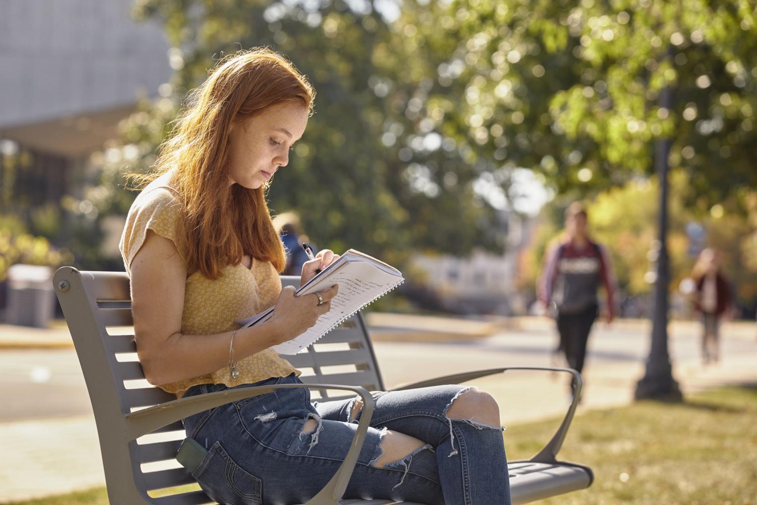 一位<a href='http://jatl.ngskmc-eis.net'>全球十大赌钱排行app</a>学院的学生在校园里的长椅上读书.